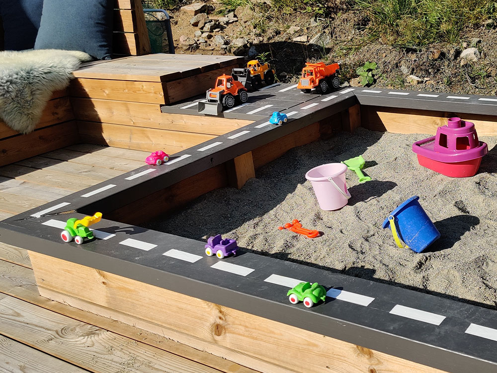 Bilde av aktivitetspark Barnas Trepris 2021. Sandkasse med malt altanrekke.