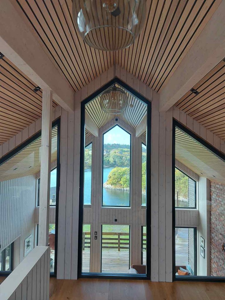 Bilde av hems hos Interiørprisfinalist nummer 4 2021. Hvitlasert panel på vegger og eikespiler i taket skaper en fin kombinasjon.
