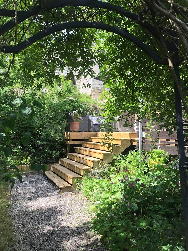 Bilde av hjemmelaget trapp tilpasset omgivelsene og terrassen til finalist i uteromsprisen 2022. 