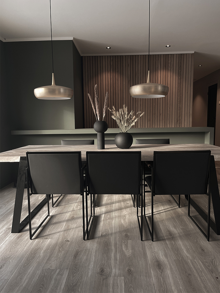 Bilde av kjøkken med mørke farger og spilevegg av eik. Finalist nummer 2 interiørprisen 2022.